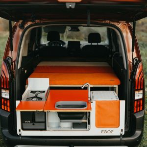 En campingmodul som är anpassad för att passa bilens baggageutrymme, med en bekväm säng, förvaringsutrymmen, en inbyggd kök med gasolspis och vattentank för en bekväm utomhusupplevelse.