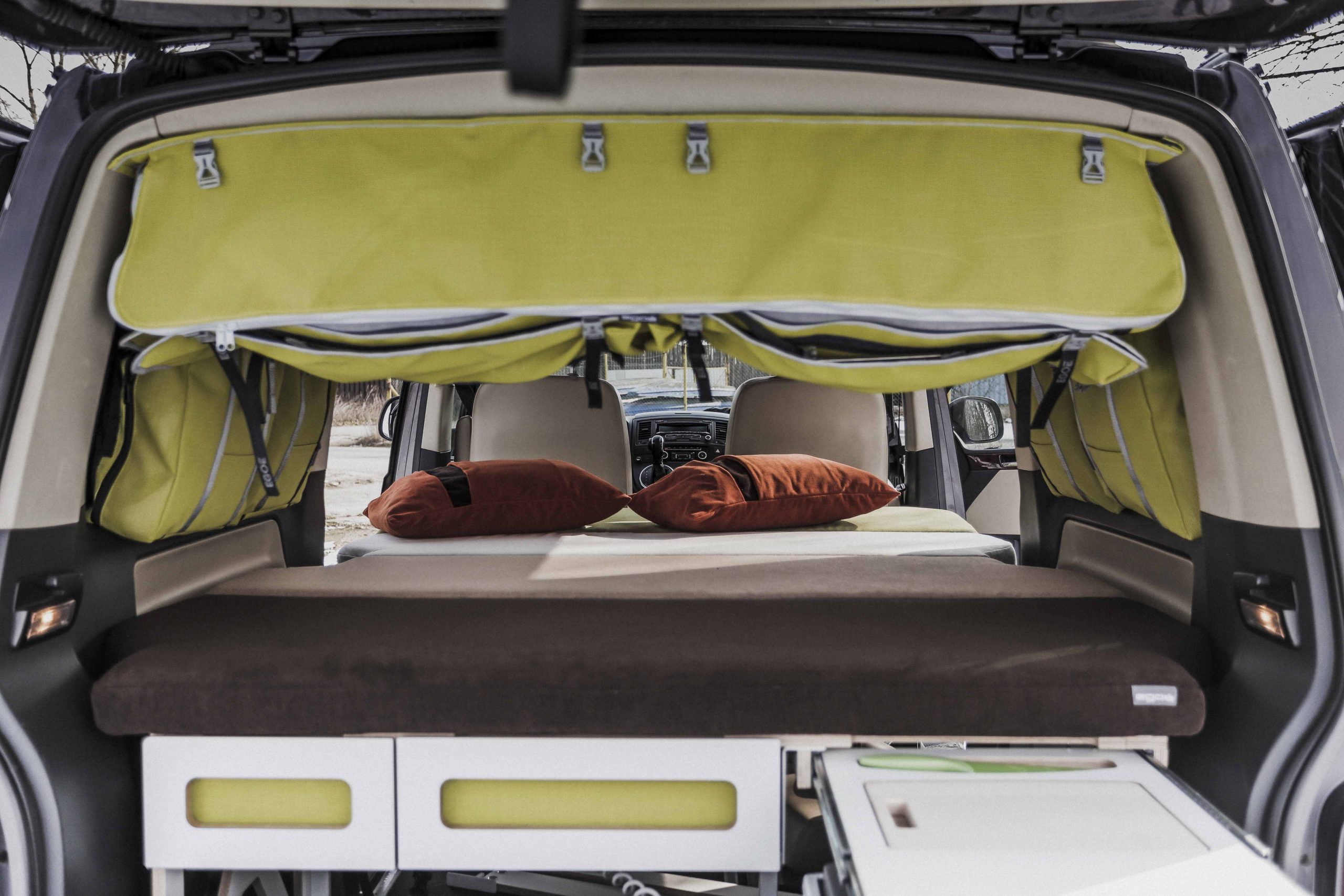 En campingmodul som är anpassad för att passa bilens baggageutrymme, med en bekväm säng, förvaringsutrymmen, en inbyggd kök med gasolspis och vattentank för en bekväm utomhusupplevelse.