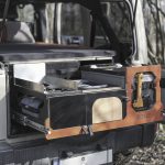 En campingmodul som är anpassad för att passa bilens baggageutrymme, med en bekväm säng, förvaringsutrymmen, en inbyggd kök med gasolspis och vattentank för en bekväm utomhusupplevelse.